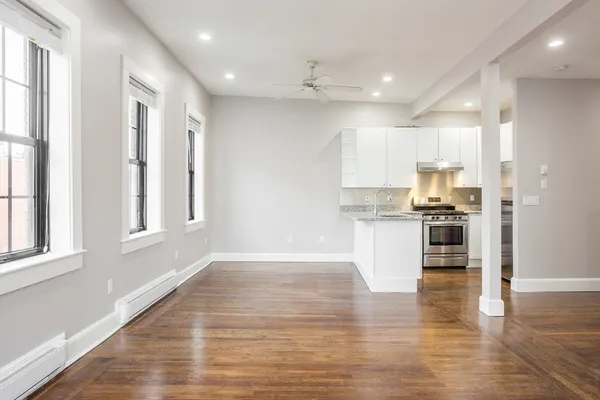 a view of kitchen with granite countertop stainless steel appliances refrigerator and cabinets