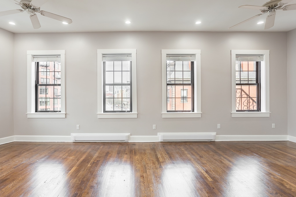 534 Tremont Street, Unit 4 Boston, MA 02118 - Photo 6 of 16 an empty room with wooden floor and windows