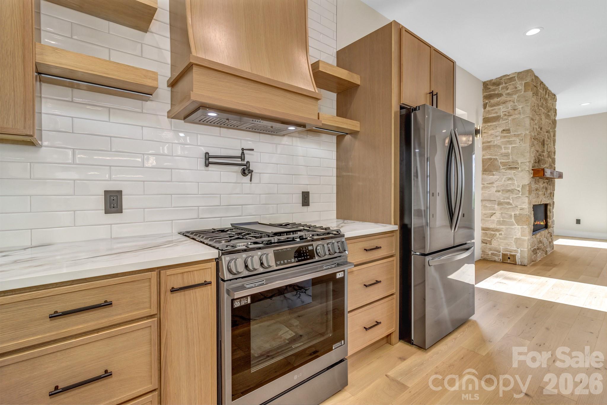 134 View Ridge Parkway Leicester, NC 28748 - Photo 13 of 48 a kitchen with stainless steel appliances wooden cabinets and a stove top oven