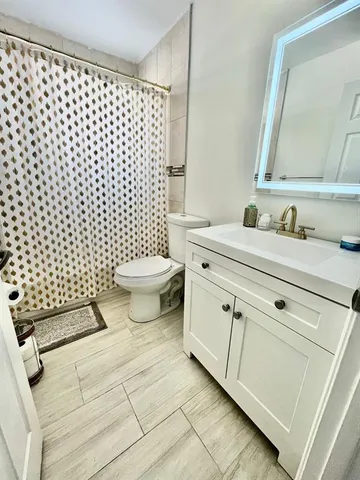 a bathroom with a sink toilet and a mirror