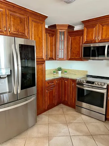 a kitchen with stainless steel appliances granite countertop a refrigerator and a stove top oven
