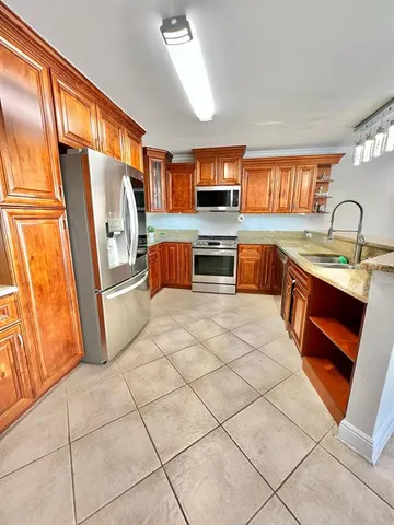 a kitchen with stainless steel appliances a sink and a refrigerator