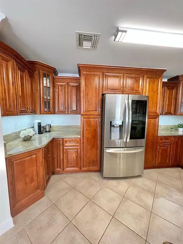 a kitchen with stainless steel appliances granite countertop a refrigerator and a stove top oven