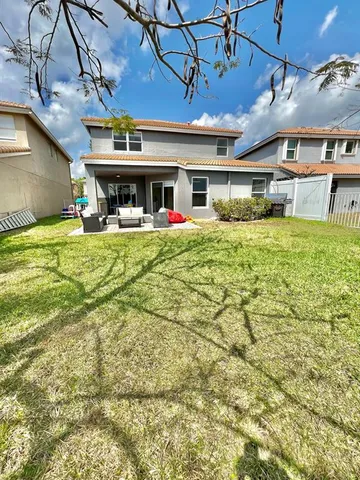 a view of a house with a backyard