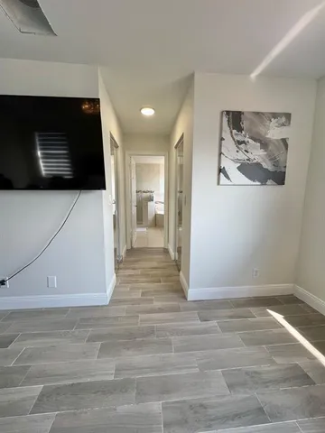 a view of a livingroom with wooden floor and a flat screen tv