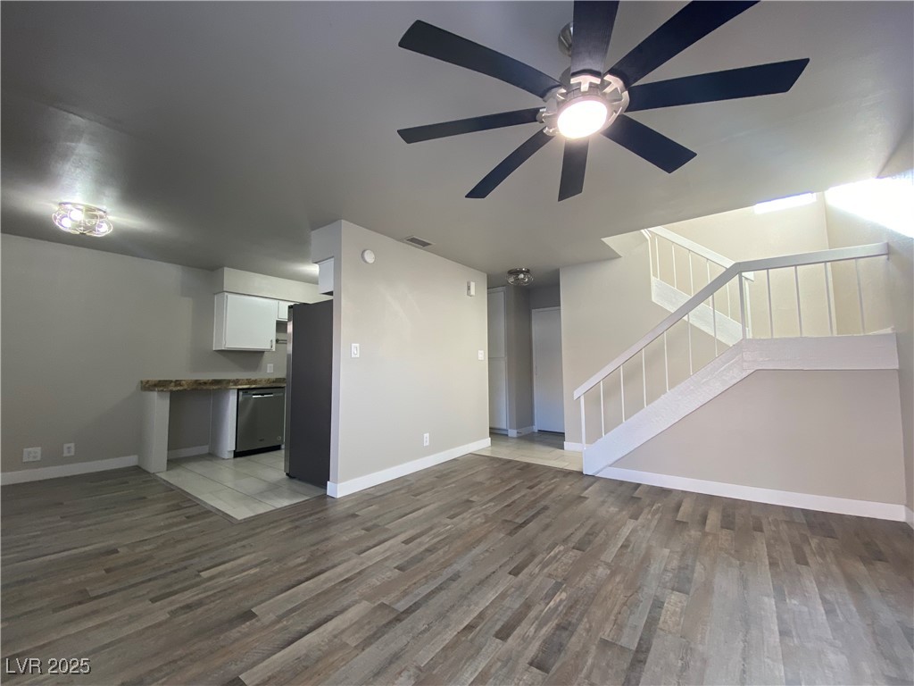 1722 East University Avenue, Unit 8 Las Vegas, NV 89119 - Photo 7 of 28 Unfurnished living room featuring stairway, light wood-type flooring, and a ceiling fan
