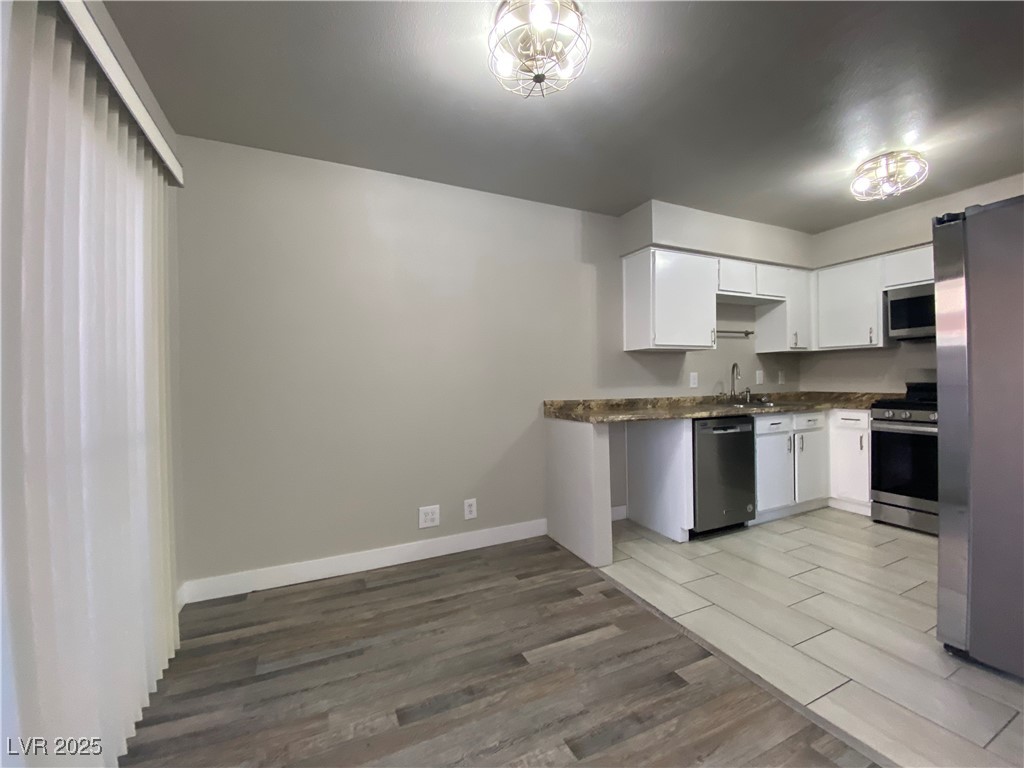 1722 East University Avenue, Unit 8 Las Vegas, NV 89119 - Photo 8 of 28 Kitchen with light wood-style floors, stainless steel appliances, and white cabinets