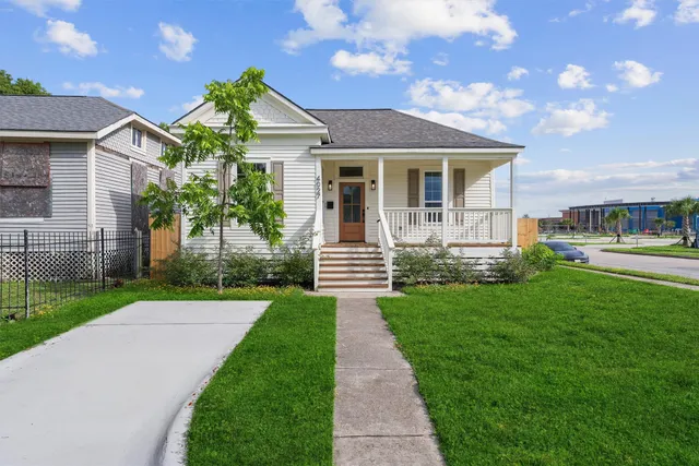 a front view of a house with a yard and garden