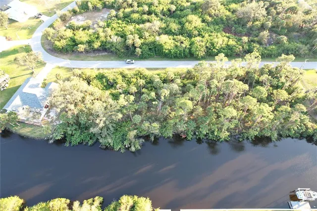 an aerial view of lake and residential houses with outdoor space