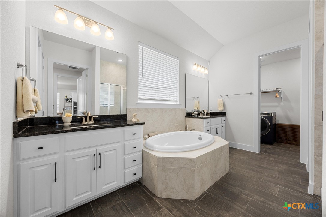 109 High Plains Drive Georgetown, TX 78628 - Photo 17 of 43 a bathroom with a double vanity sink a mirror and a bathtub