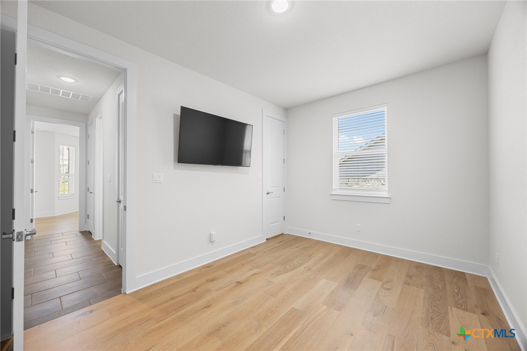 109 High Plains Drive Georgetown, TX 78628 - Photo 30 of 43 a view of a livingroom with wooden floor and a flat screen tv