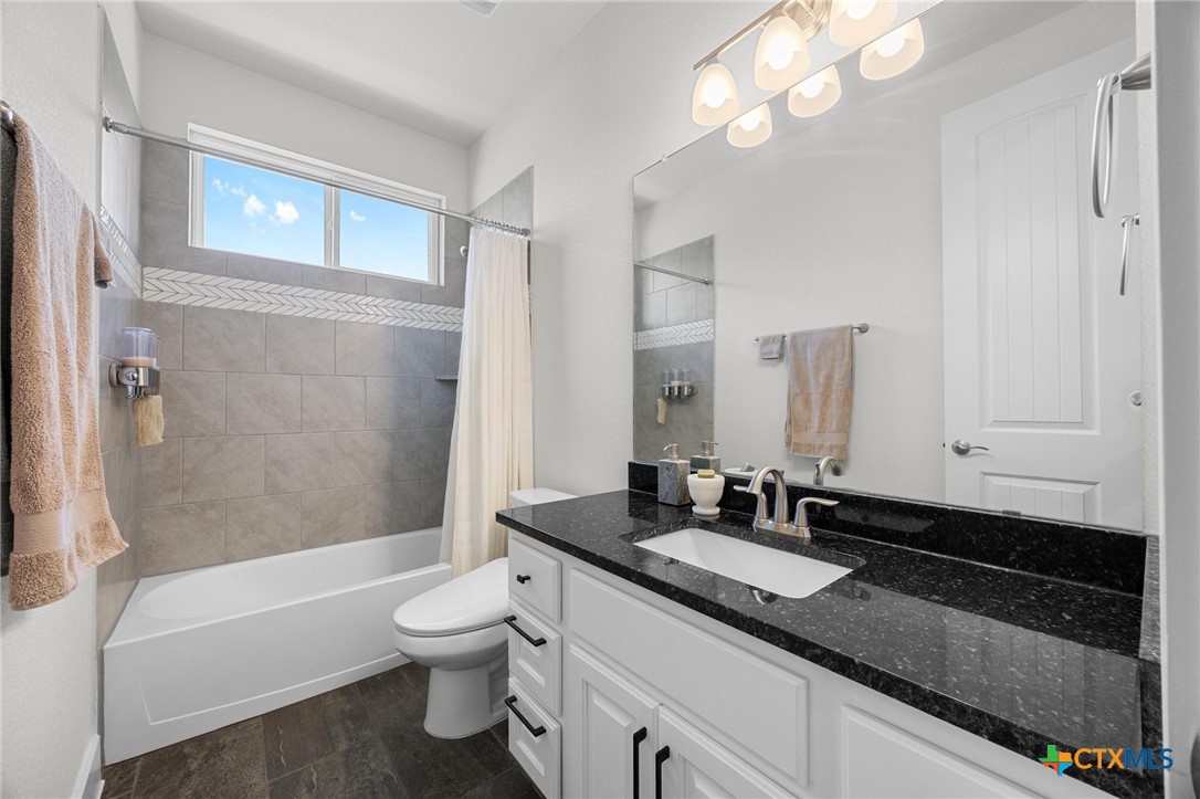 109 High Plains Drive Georgetown, TX 78628 - Photo 31 of 43 a bathroom with a granite countertop sink a toilet and bathtub