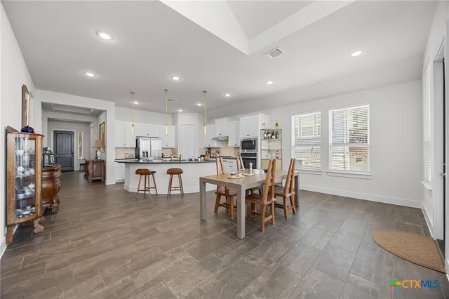 a kitchen with granite countertop white cabinets and white appliances