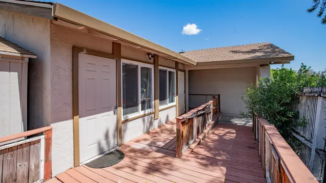 a view of a balcony with wooden floor and fence