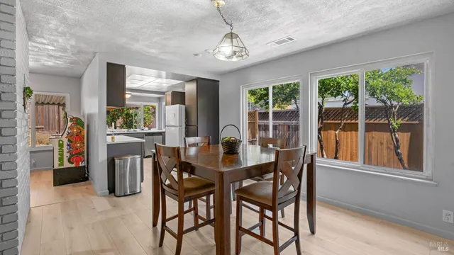 a dining room with furniture large windows and a chandelier