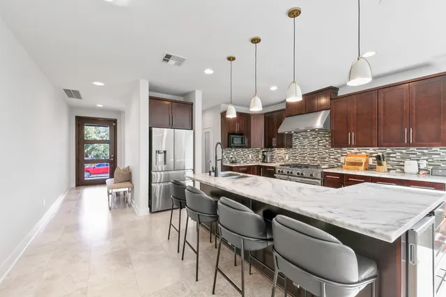 a kitchen with granite countertop a table and chairs in it