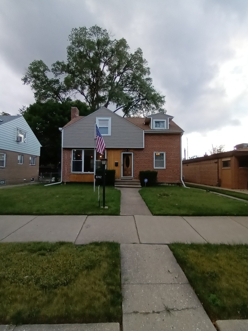 a front view of a house with a garden