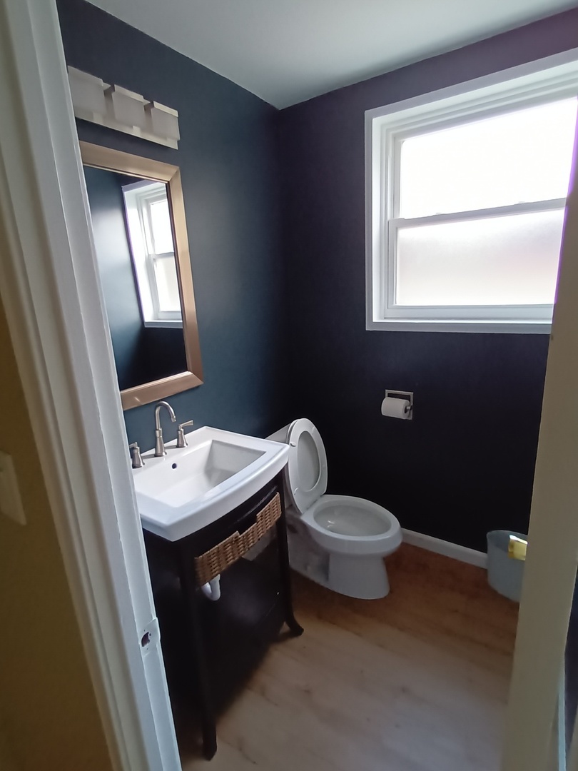 8742 East Prairie Road Skokie, IL 60076 - Photo 13 of 29 a bathroom with a toilet sink and mirror