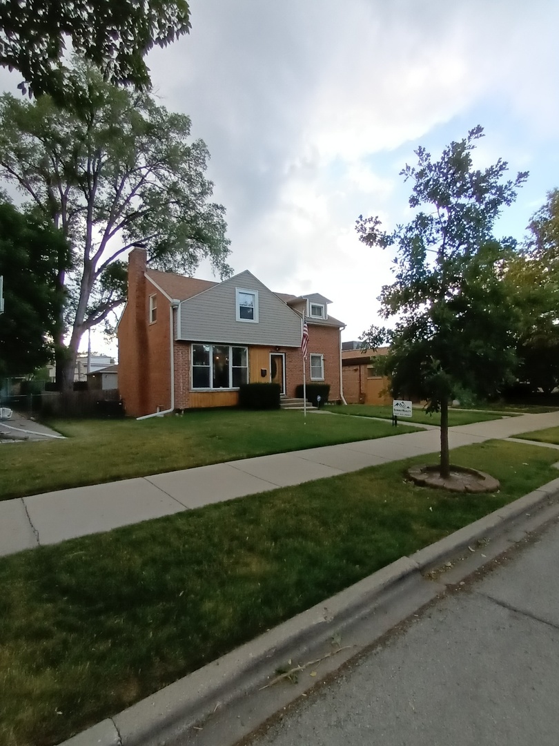 8742 East Prairie Road Skokie, IL 60076 - Photo 2 of 29 a front view of a house with a yard