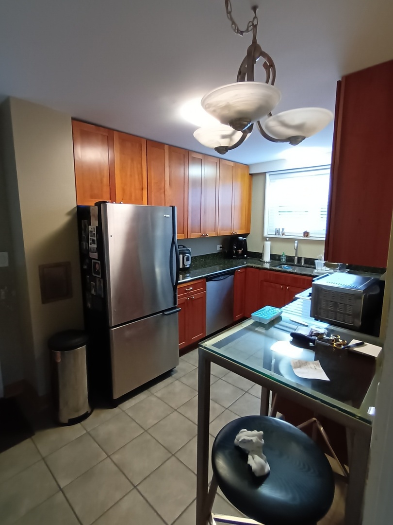 8742 East Prairie Road Skokie, IL 60076 - Photo 9 of 29 a kitchen with stainless steel appliances granite countertop a sink refrigerator and microwave