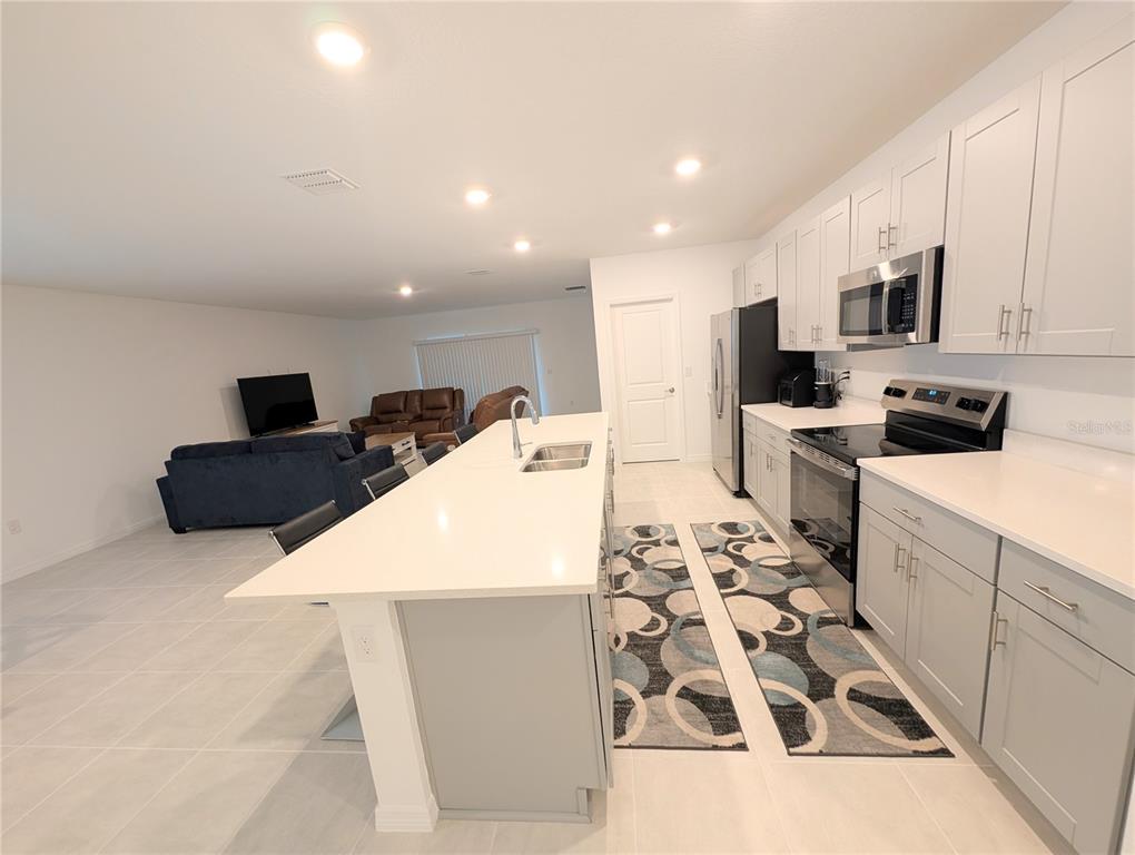 152 Jones Fish Camp Road Edgewater, FL 32141 - Photo 11 of 28 a kitchen with stainless steel appliances kitchen island sink refrigerator and stove