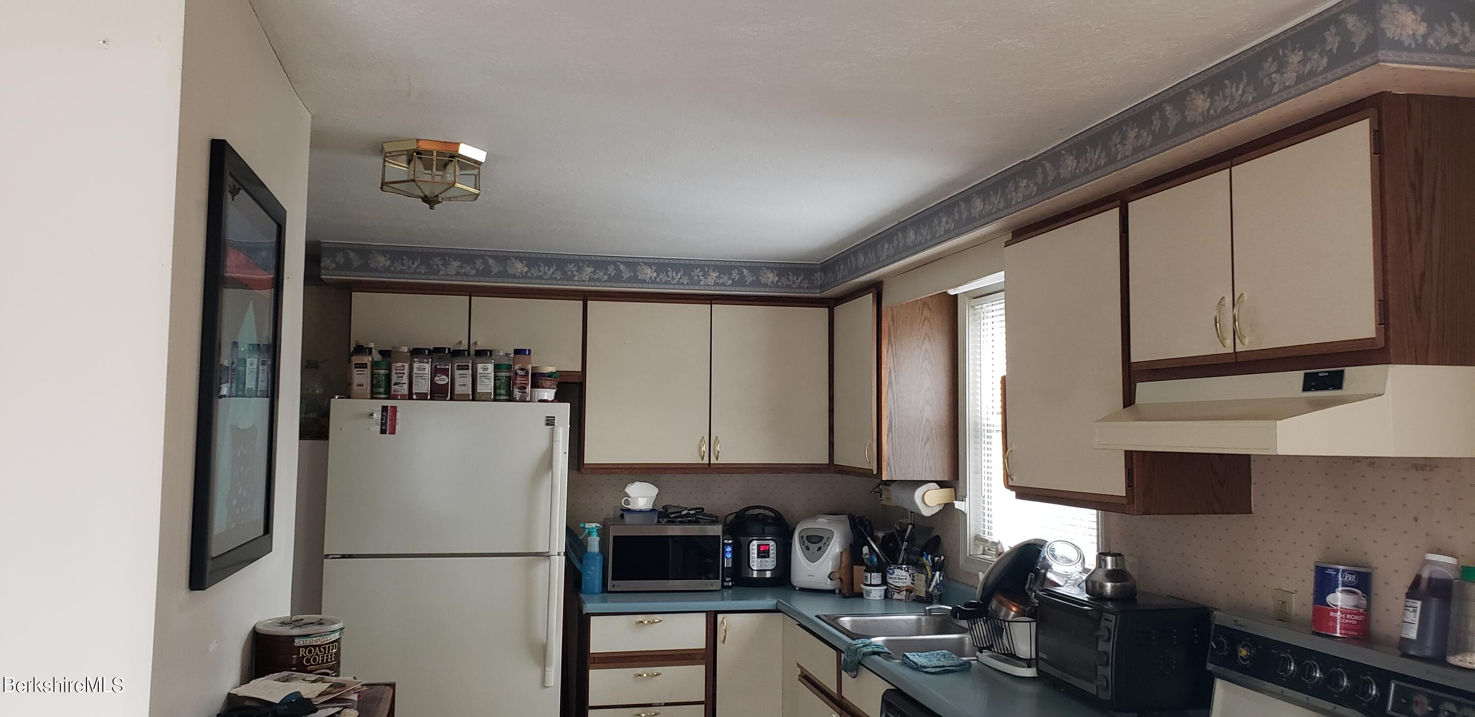 219-221 Church Street North Adams, MA 01247 - Photo 29 of 43 a kitchen with a refrigerator and a sink