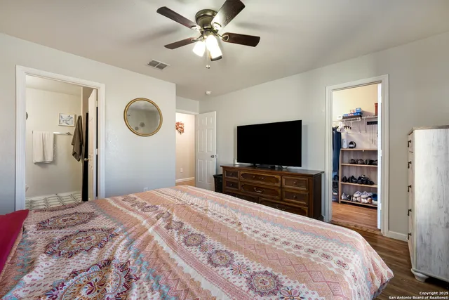 a bedroom with a bed and a flat tv screen on dresser