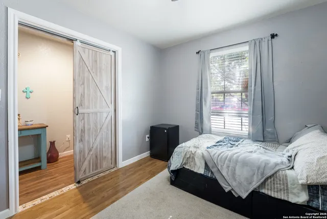 a bedroom with a bed and wooden floor
