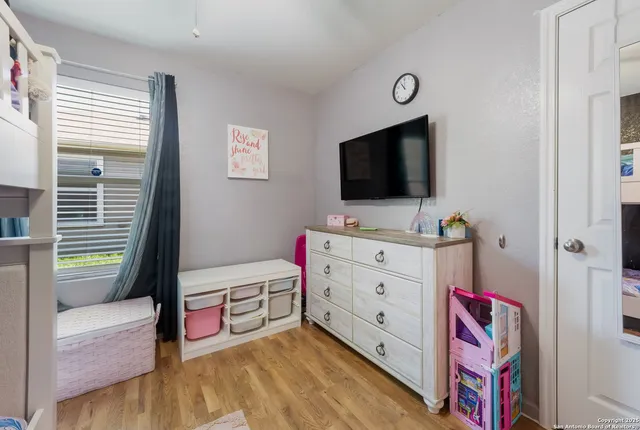 a bedroom with furniture and a flat screen tv