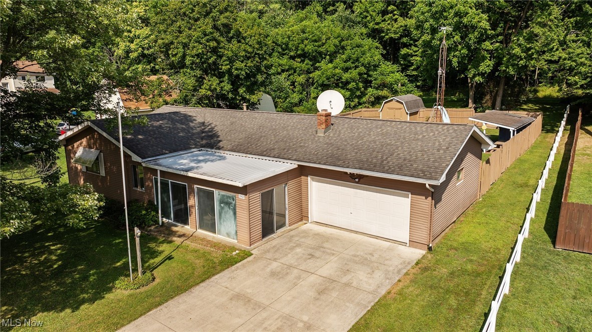 3907 Edwards Street Mineral Ridge, OH 44440 - Photo 1 of 45 View of front facade with a shingled roof, driveway, an attached garage, and a chimney