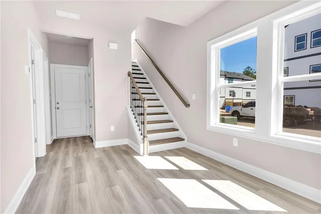 a view of a hallway with wooden floor and entryway