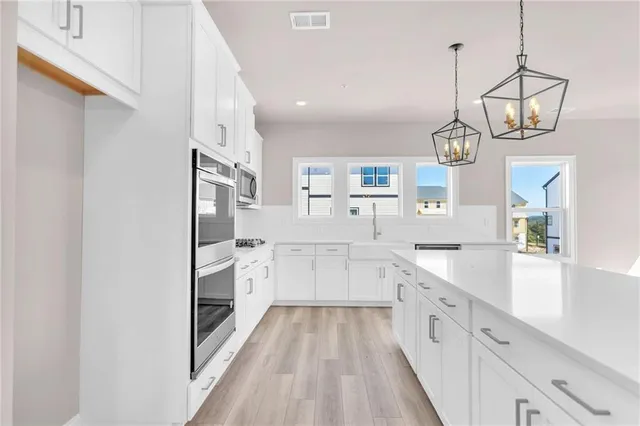 a large kitchen with a lot of counter space and wooden floor