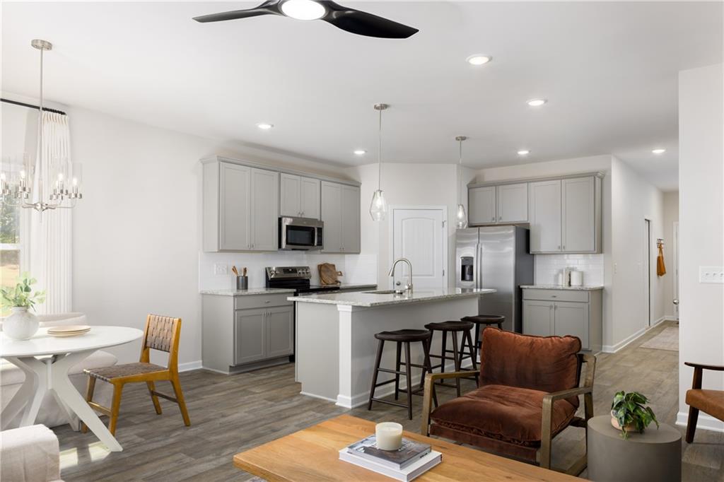 4809 Orchard Grove Way, Unit 178 Gainesville, GA 30504 - Photo 4 of 18 a kitchen with stainless steel appliances kitchen island granite countertop a refrigerator a stove a sink a dining table and chairs with wooden floor