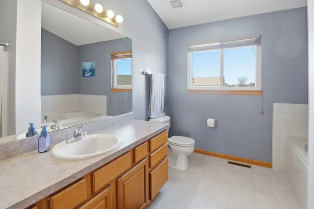 a bathroom with a granite countertop sink toilet and mirror
