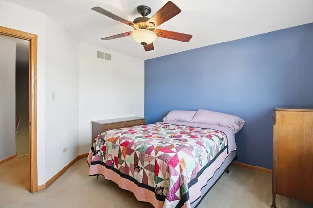 a bedroom with a bed and a ceiling fan