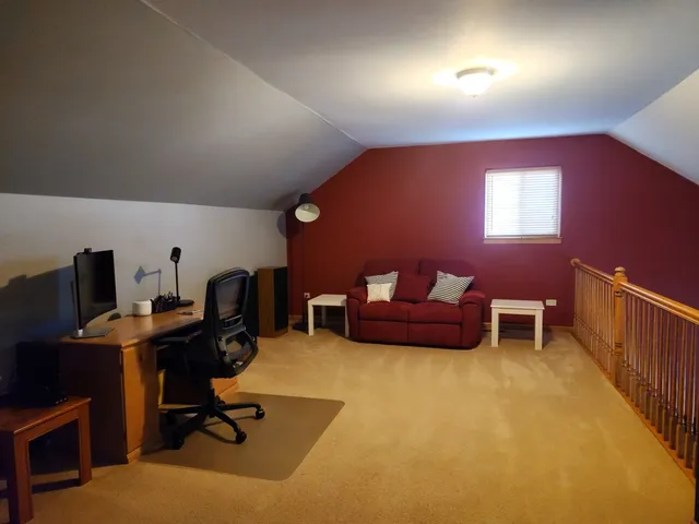 a view of a workspace with furniture and a window