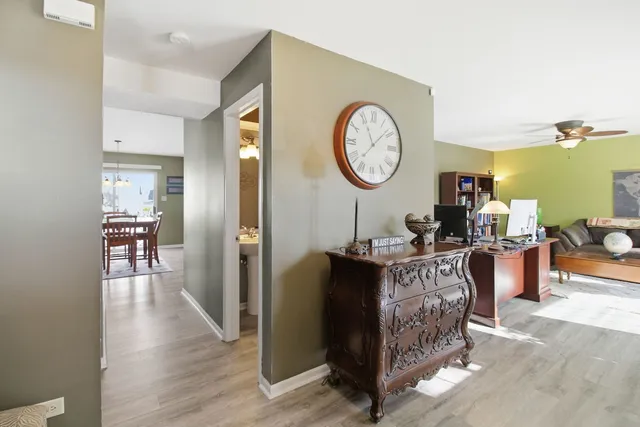 a living room with furniture a wooden floor and a clock