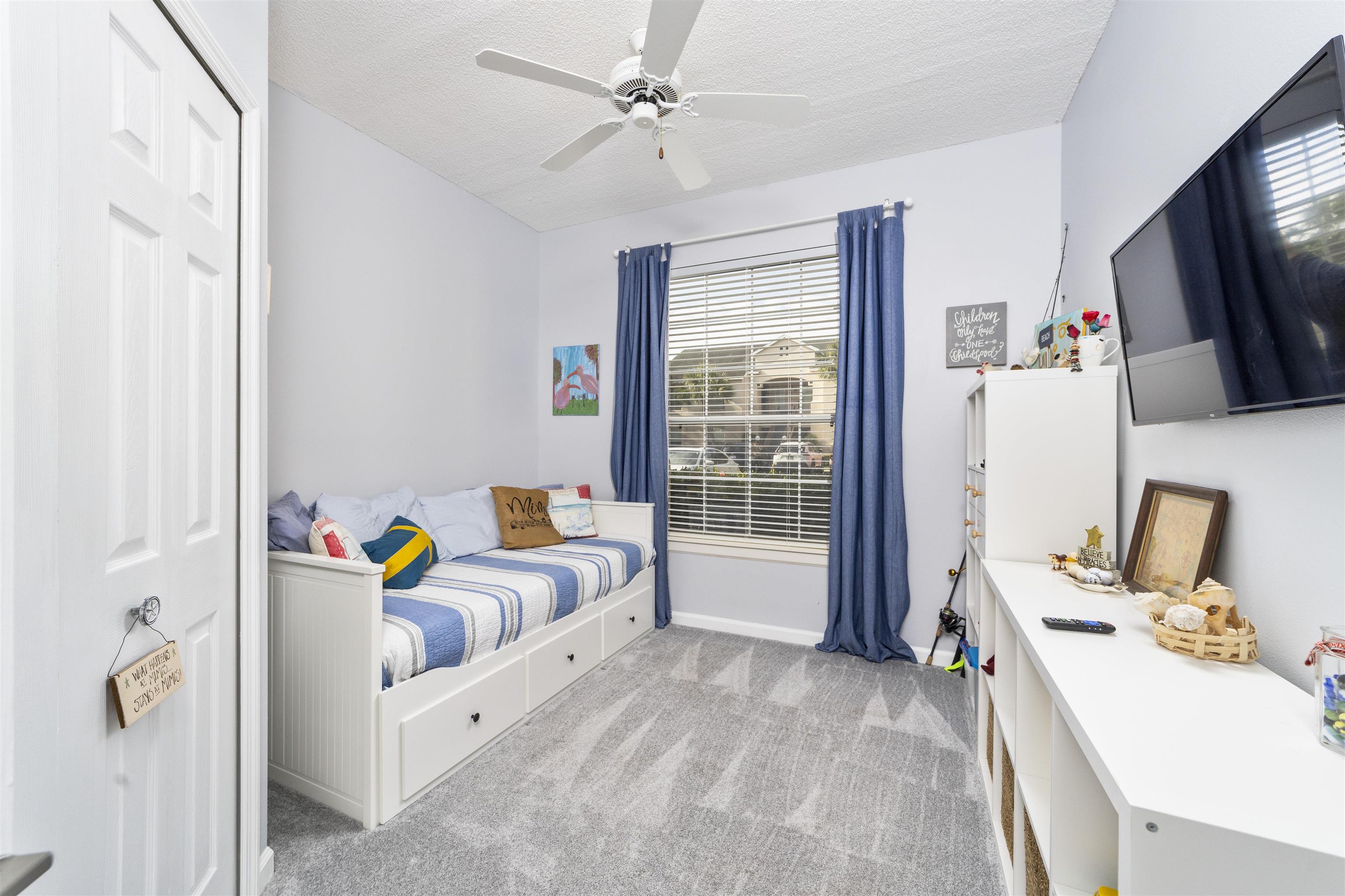 208 Augusta Circle St. Augustine, FL 32086 - Photo 29 of 34 a bedroom with furniture a flat screen tv and a window