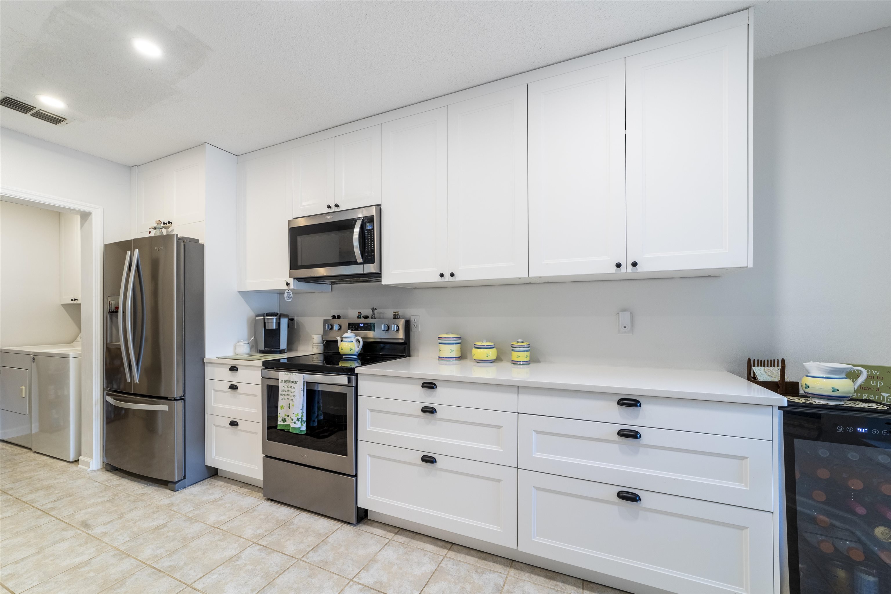208 Augusta Circle St. Augustine, FL 32086 - Photo 7 of 34 a kitchen with stainless steel appliances white cabinets and a refrigerator