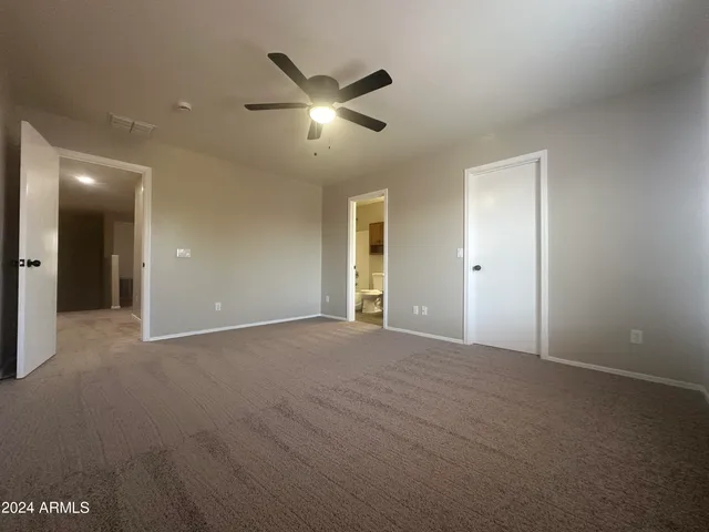 a view of an empty room with a chandelier fan
