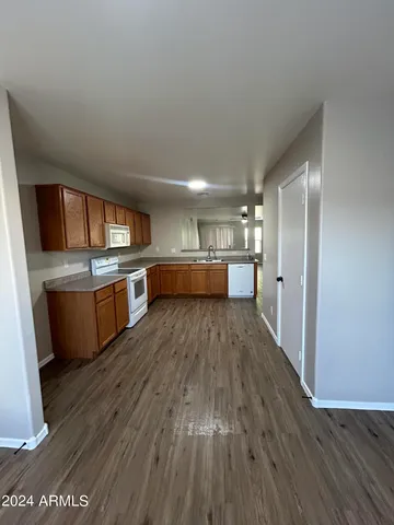 a kitchen with kitchen island wooden floors and stainless steel appliances