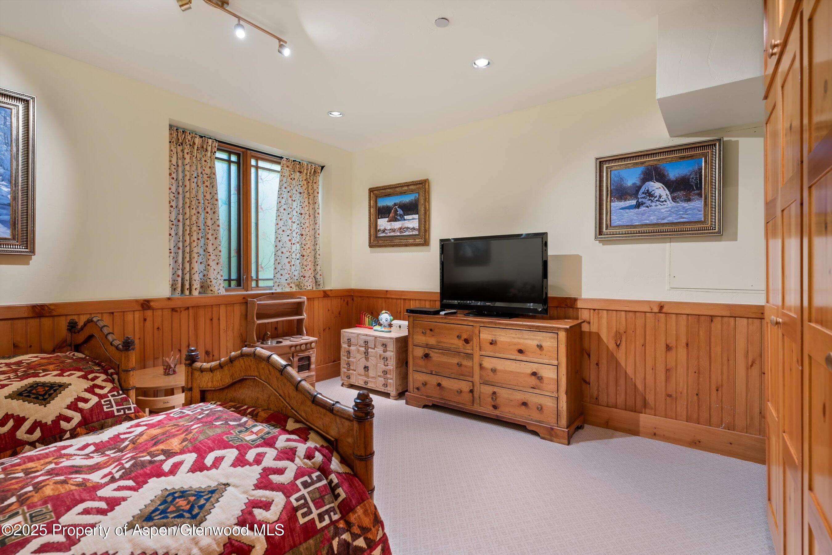 195 North Hayden Road Aspen, CO 81611 - Photo 31 of 39 a bedroom with furniture and a flat screen tv