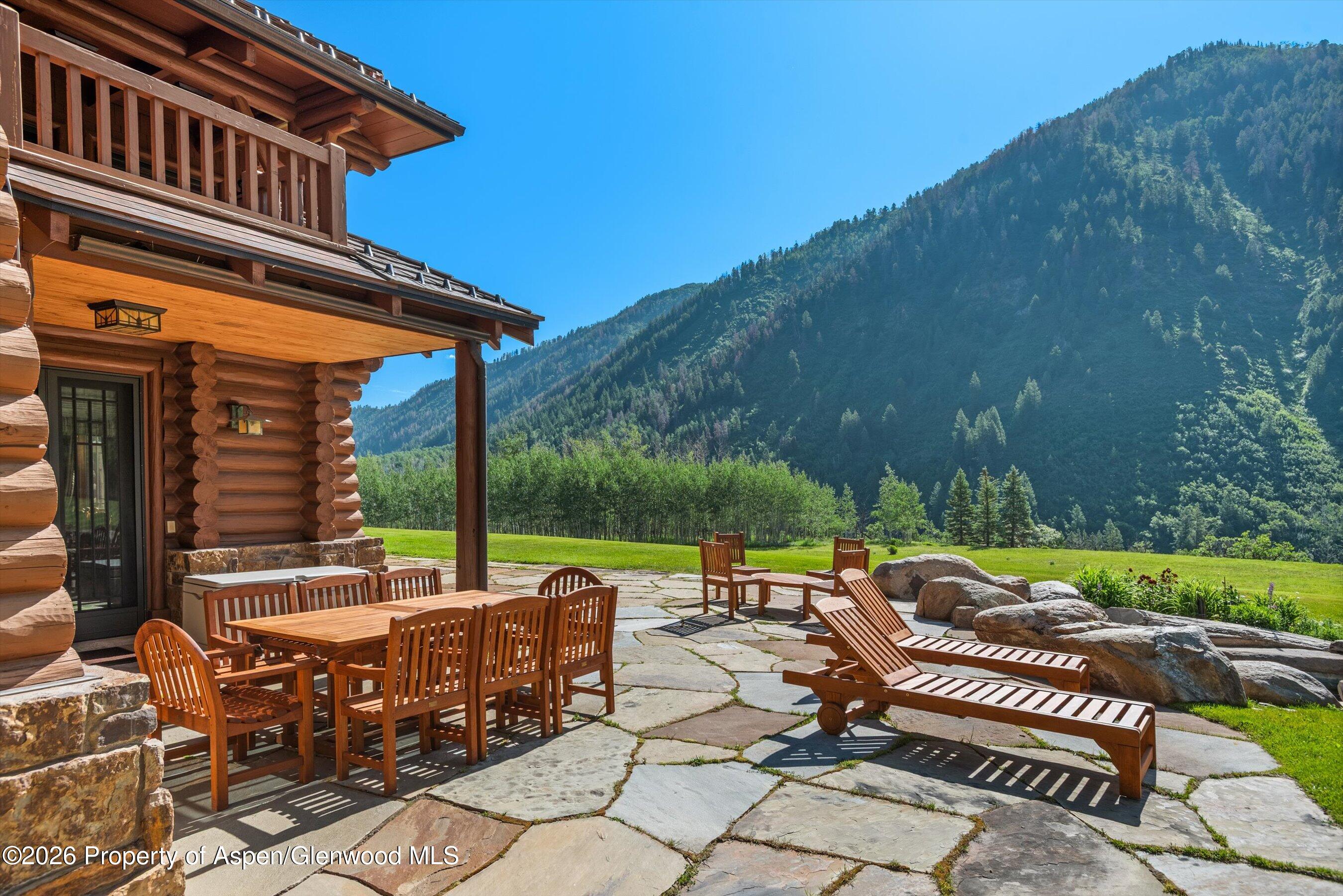 195 North Hayden Road Aspen, CO 81611 - Photo 38 of 39 a view of a patio with table and chairs under an umbrella with a patio