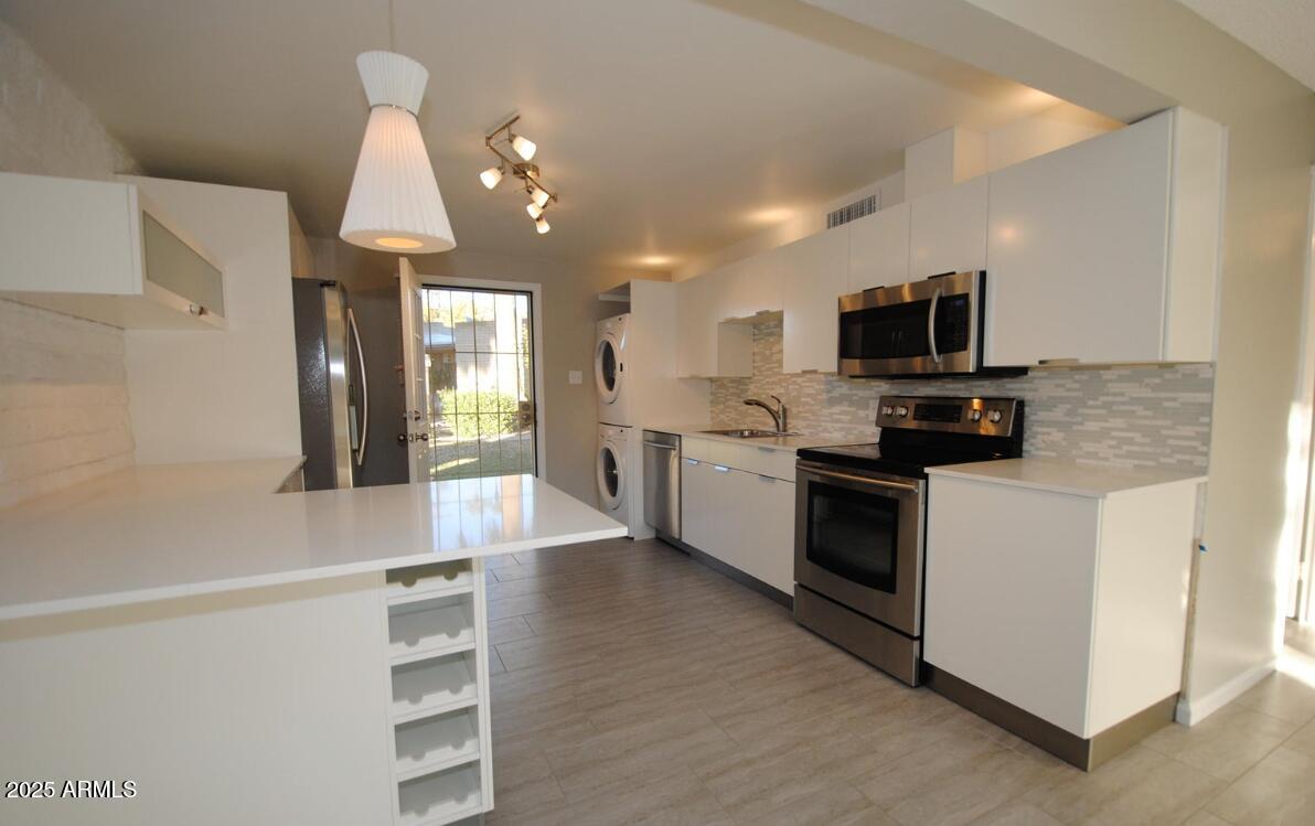 4351 North 36th Place, Unit 3 Phoenix, AZ 85018 - Photo 2 of 11 a kitchen with stainless steel appliances kitchen island granite countertop a stove a sink and a refrigerator