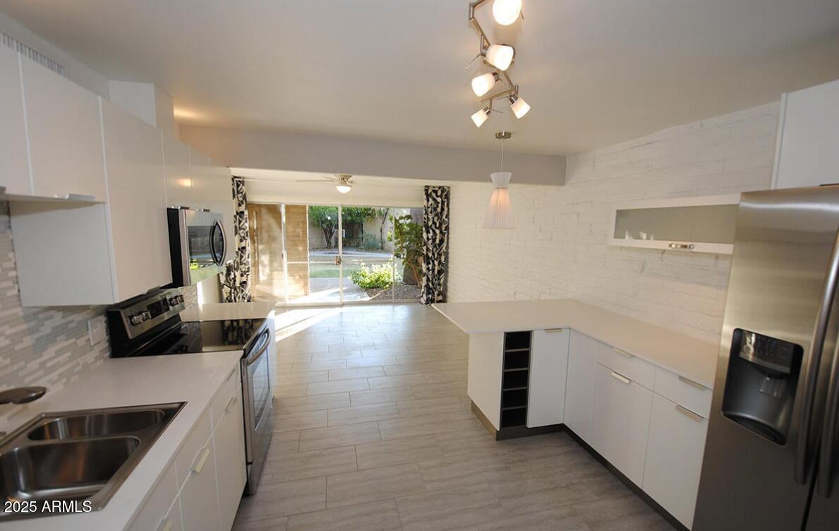 4351 North 36th Place, Unit 3 Phoenix, AZ 85018 - Photo 4 of 11 a view of a kitchen with a sink and dishwasher a refrigerator with wooden floor