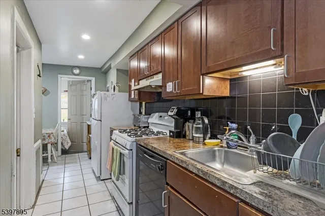 a kitchen with stainless steel appliances granite countertop a sink and a refrigerator