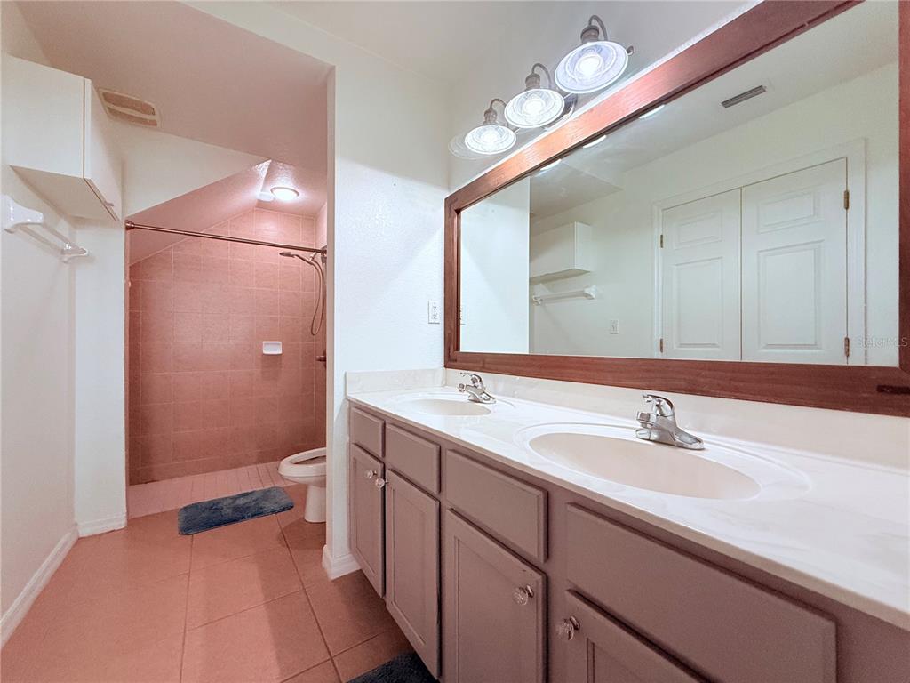 100 Turpial Way, Unit 107 Melbourne, FL 32901 - Photo 14 of 16 a bathroom with a sink a toilet and a mirror