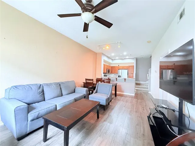 a living room with furniture and a wooden floor