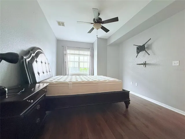 a bed sitting in a room next to a window and a chandelier