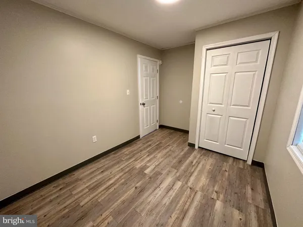 a view of a room with wooden floor and white doors